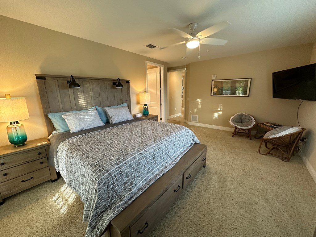a bedroom with a bed and a ceiling fan