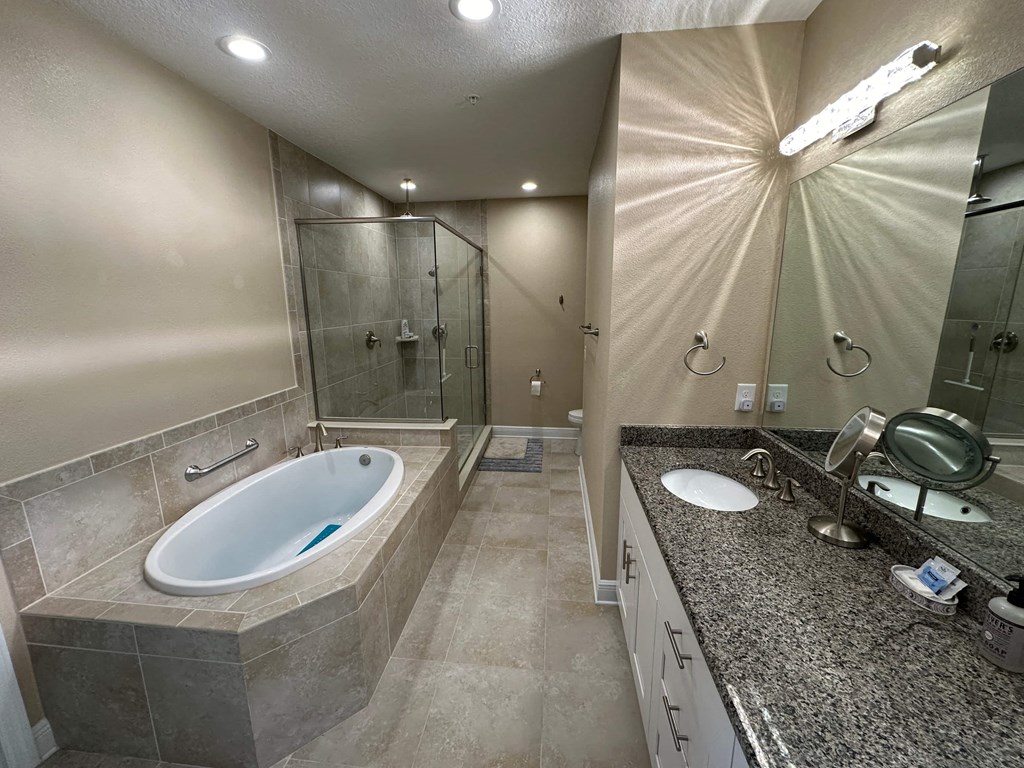 a large bathroom with a tub and a sink and a shower