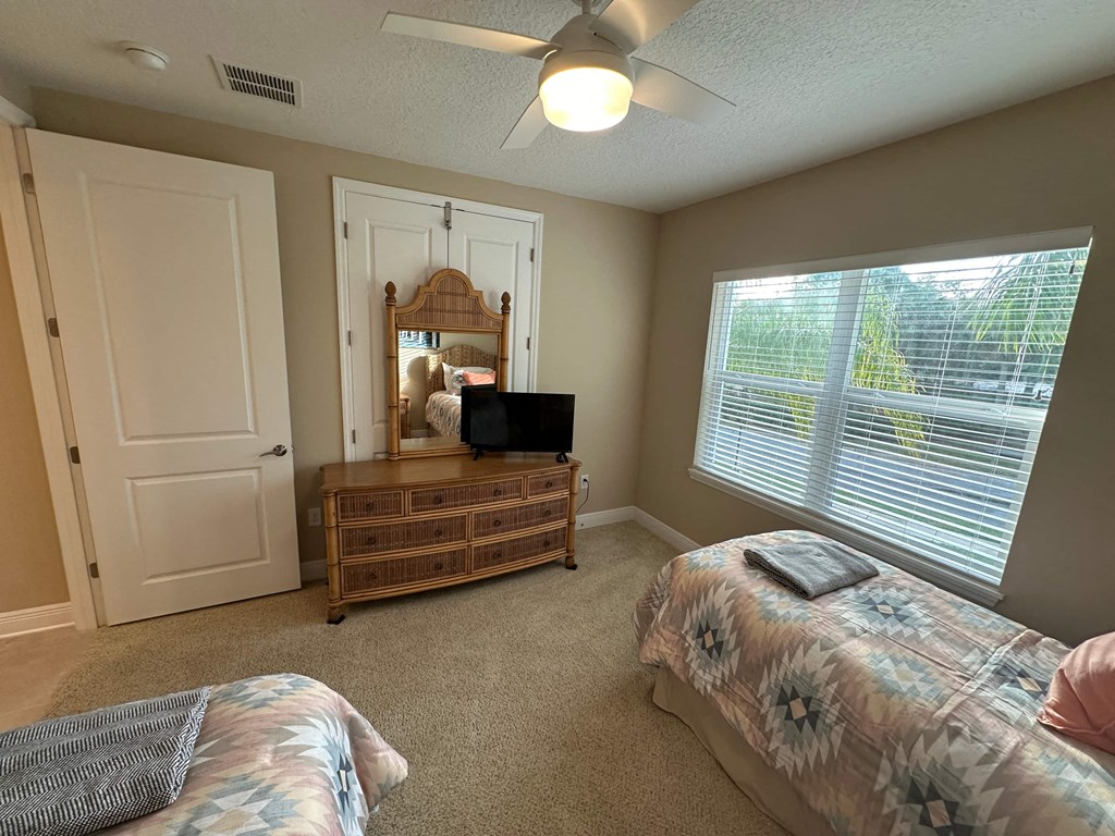 a bedroom with a bed and a dresser with a tv