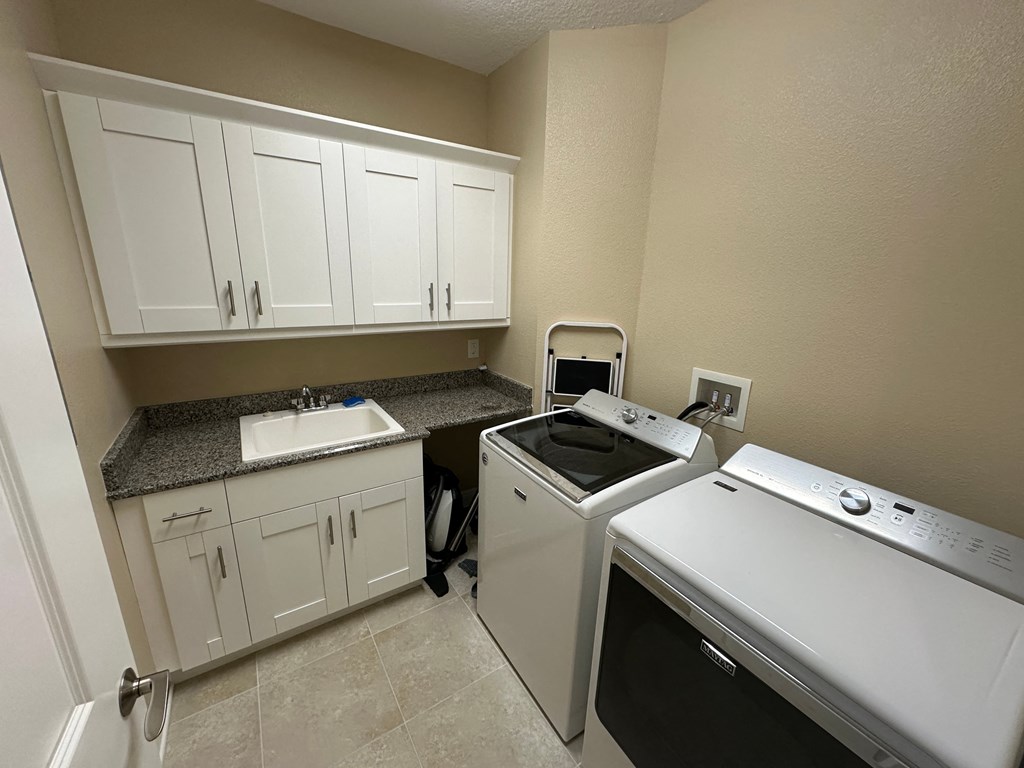 a kitchen with a washer and dryer and a sink