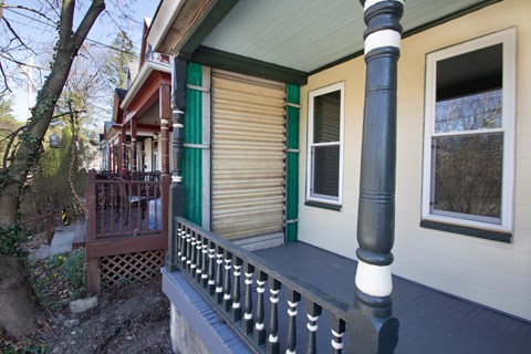 the front porch of a house with a wooden railing