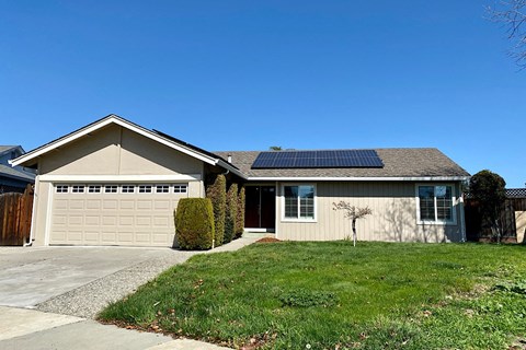 A house with a garage and solar panels on the roof.