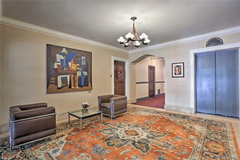 a living room with furniture and a painting on the wall