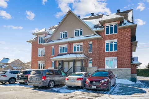 a large brick house with cars parked in front of it