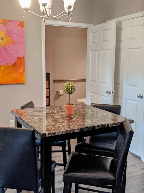 a dining room with a marble table and black chairs