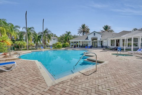 a large swimming pool with a house in the background