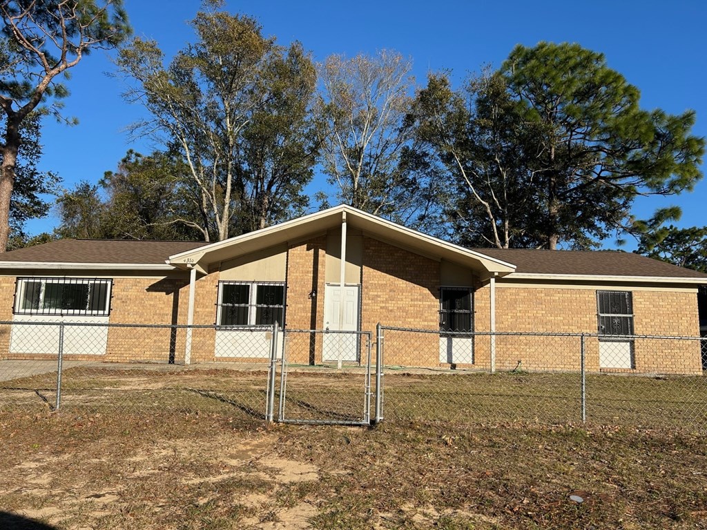 a house in a fenced in area with a chain link fence