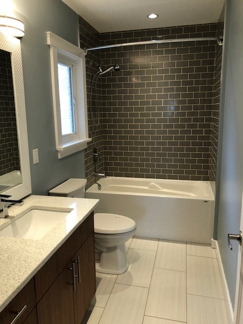 a bathroom with a toilet and a tub and a sink