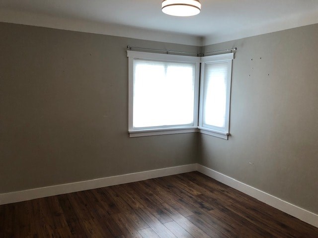 an empty room with a window and a wooden floor