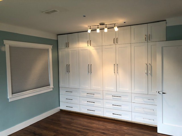 an empty room with white cabinets and a window