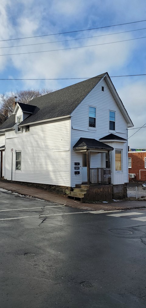 a white house on the corner of a street