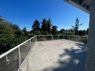 a balcony with a railing and trees in the background
