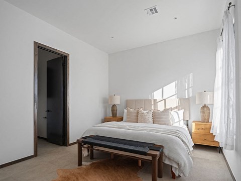 A bedroom with a bed, nightstands, and a rug.
