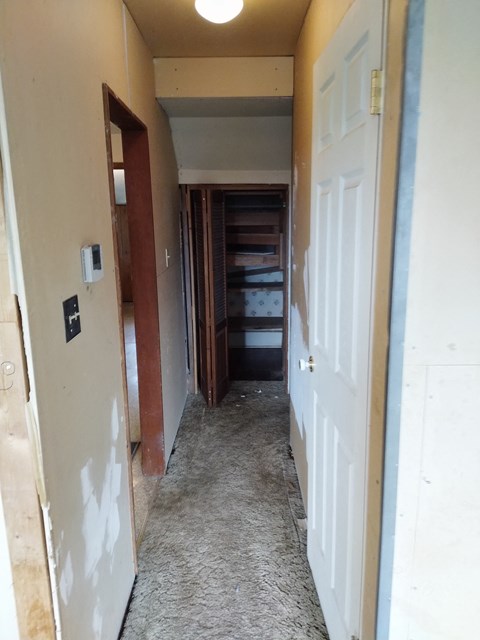a view of the hallway from the living room looking into the bedroom and closet