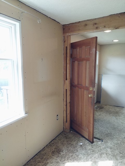 a bedroom with a wooden door and a window