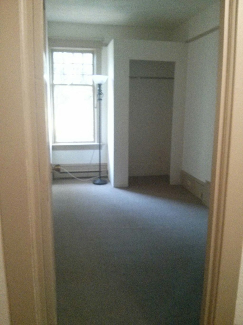an empty room with a closet and a window