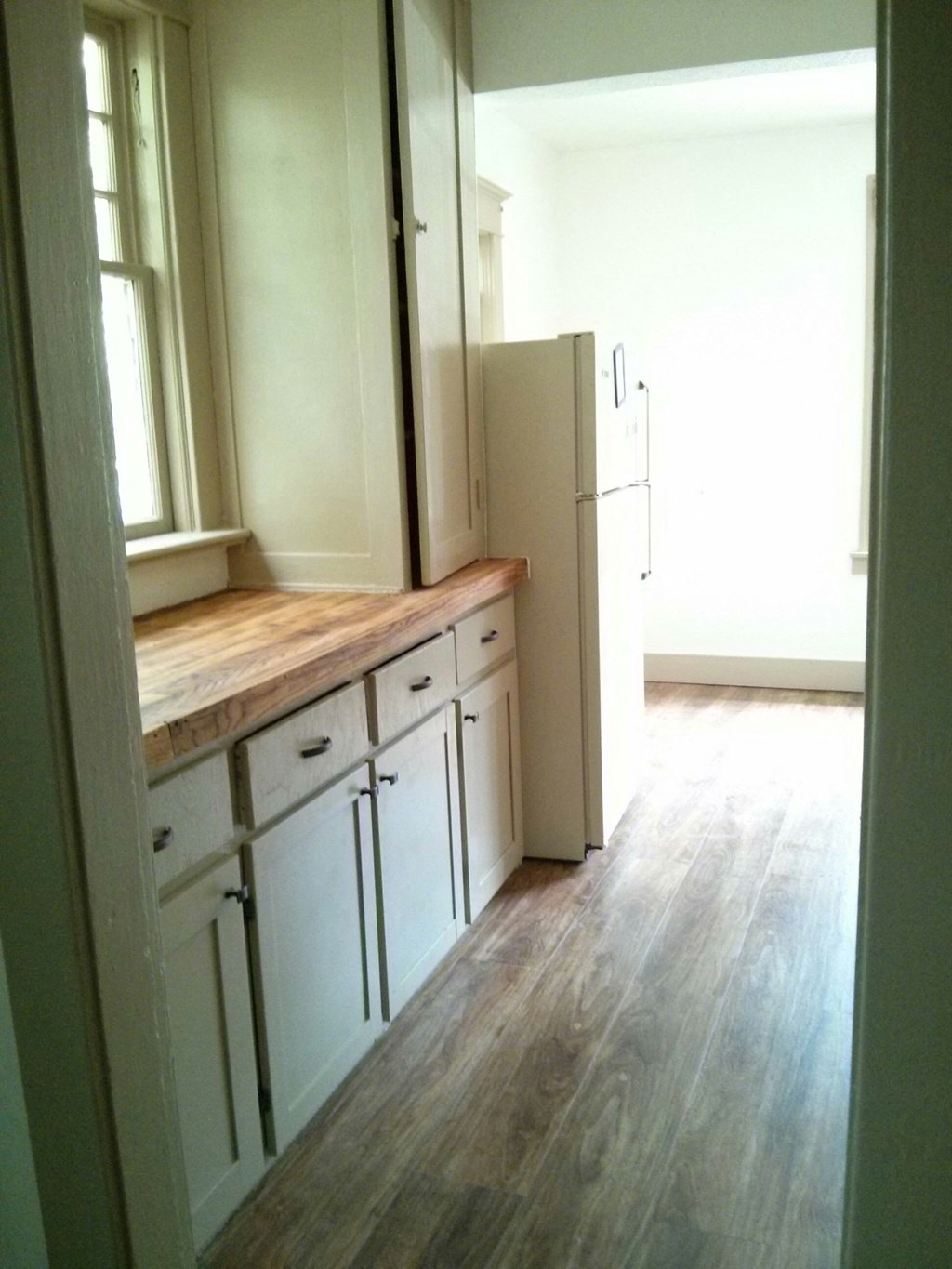 a kitchen with white cabinets and a wood floor