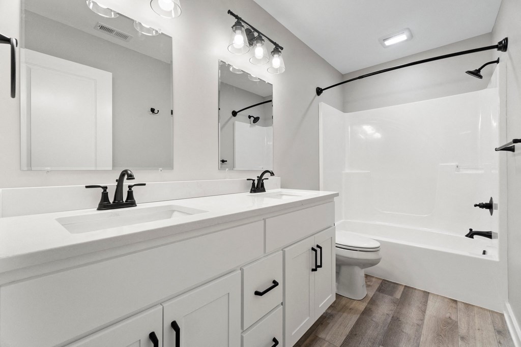 a bathroom with two sinks and a shower and a toilet