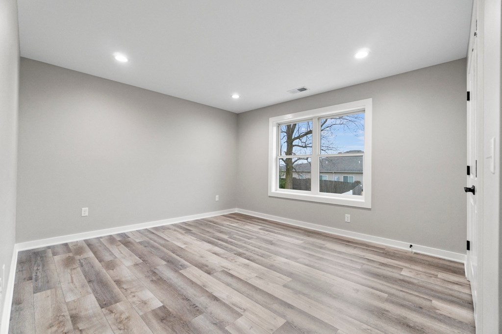 an empty room with wood floors and a window