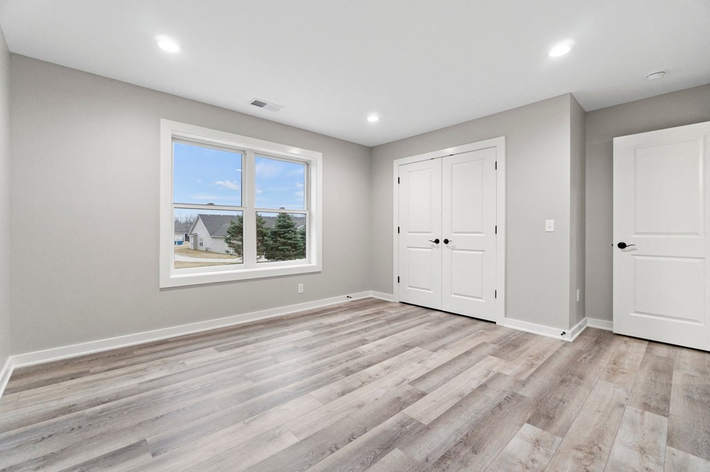 an empty living room with white doors and a window