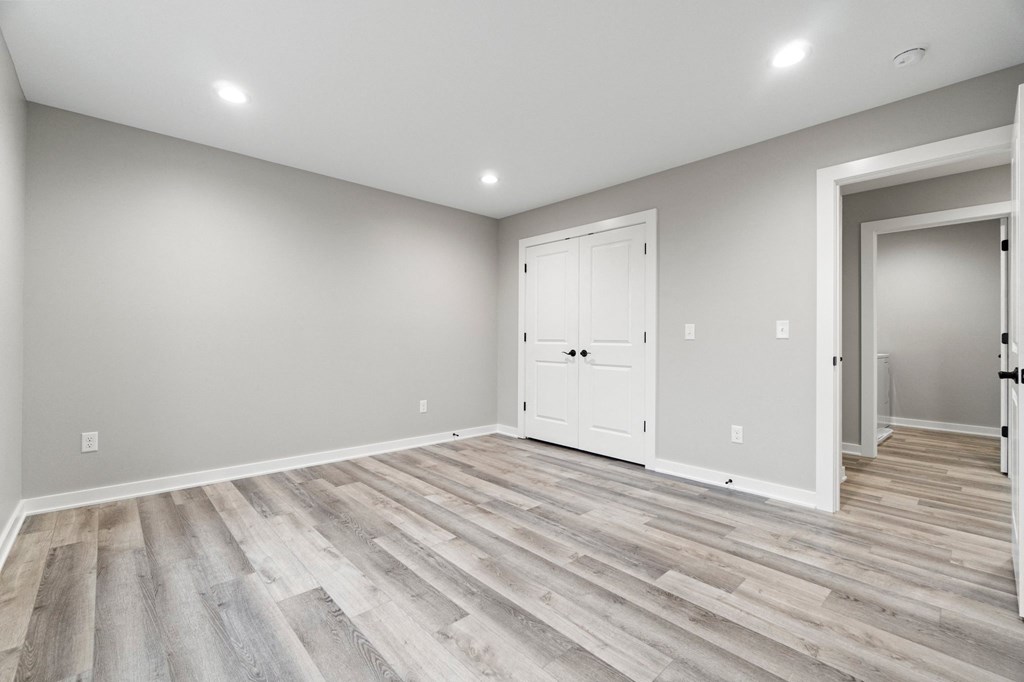 the living room of a new home with grey walls and wood flooring