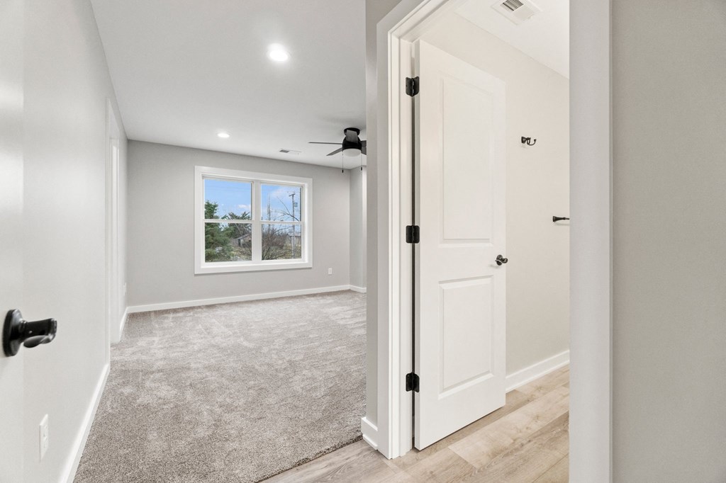 an empty room with a white door and a window