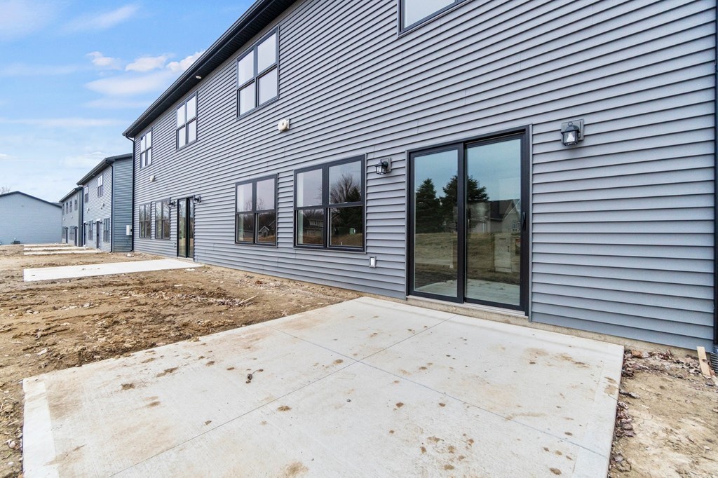 the outside of a house with a patio and sliding glass doors