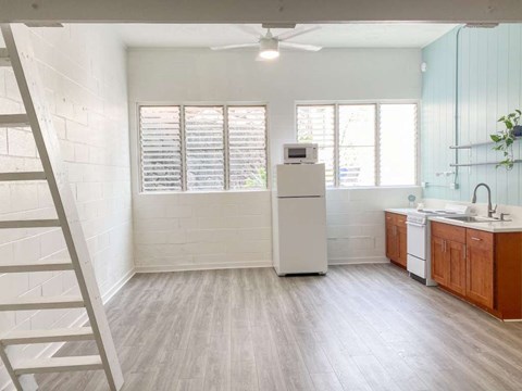 A white kitchen with wooden cabinets and a white fridge.