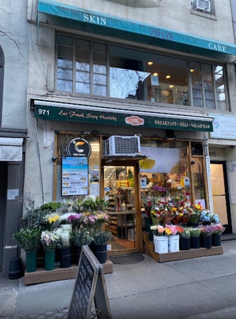 the front of a flower shop on a city street