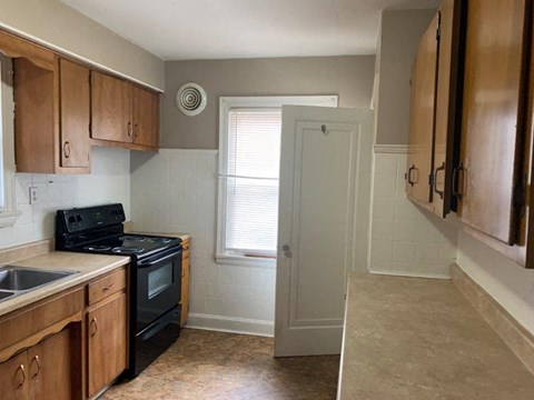 A kitchen with wooden cabinets and black appliances.