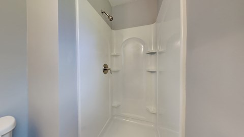 a white bathroom with a shower and a sink