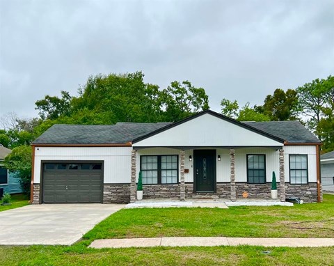 A house with a grey garage door and a black front door.