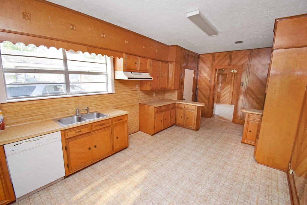 a kitchen with wooden cabinets and a sink and a window
