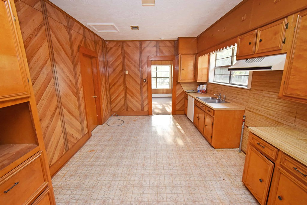 a kitchen with wooden walls and a white tile floor