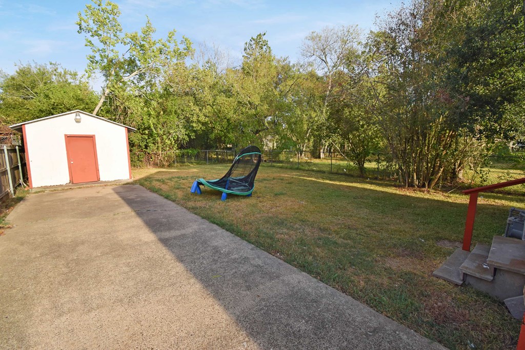 a park bench in a yard next to a small building