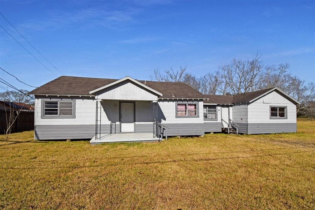 a small white house in a field with a blue sky