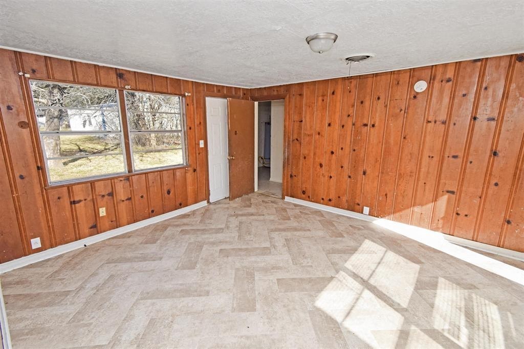 an empty living room with wooden walls and wood flooring