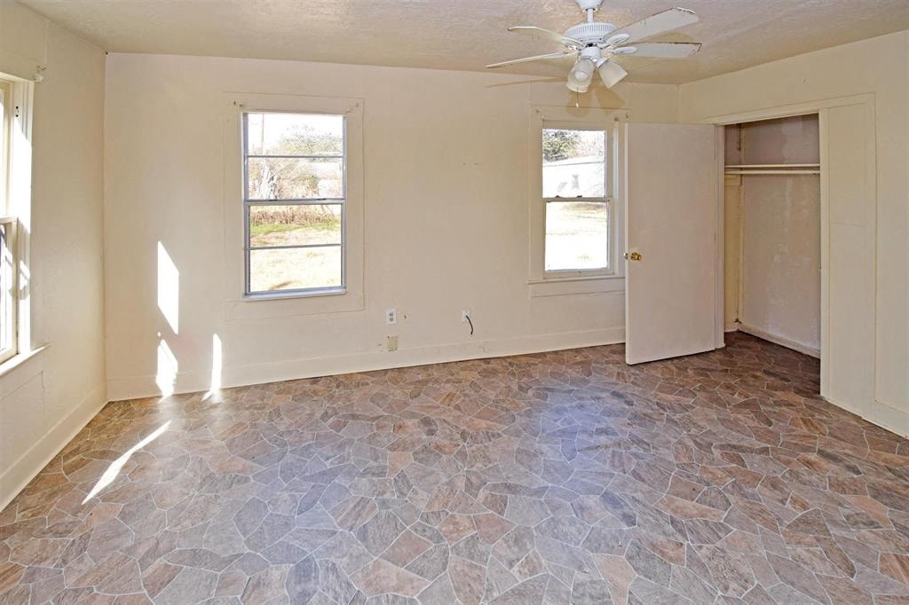 an empty living room with a ceiling fan
