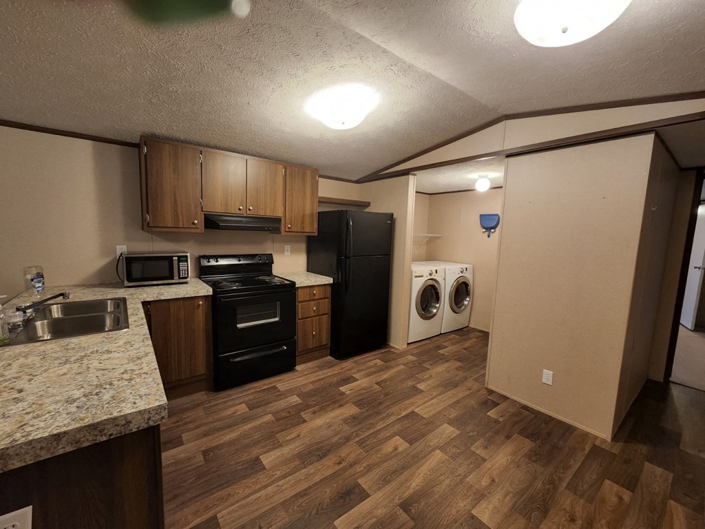 a kitchen with a washer and dryer and a sink