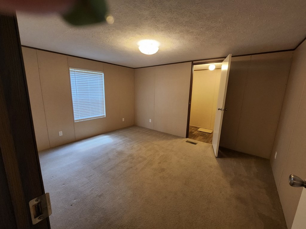 an empty room with a door and a window