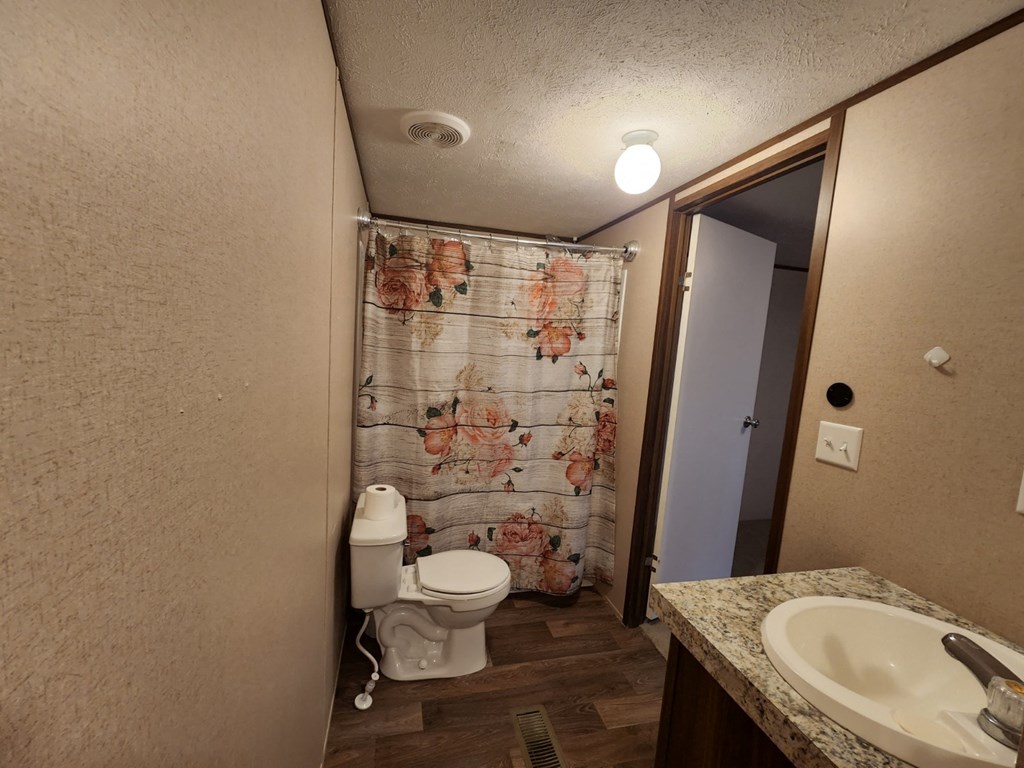 a bathroom with a toilet and a shower with a curtain