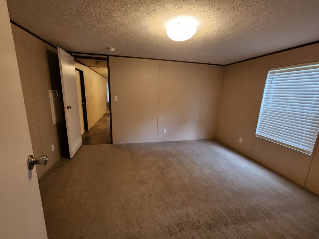 an empty living room with a window and a door