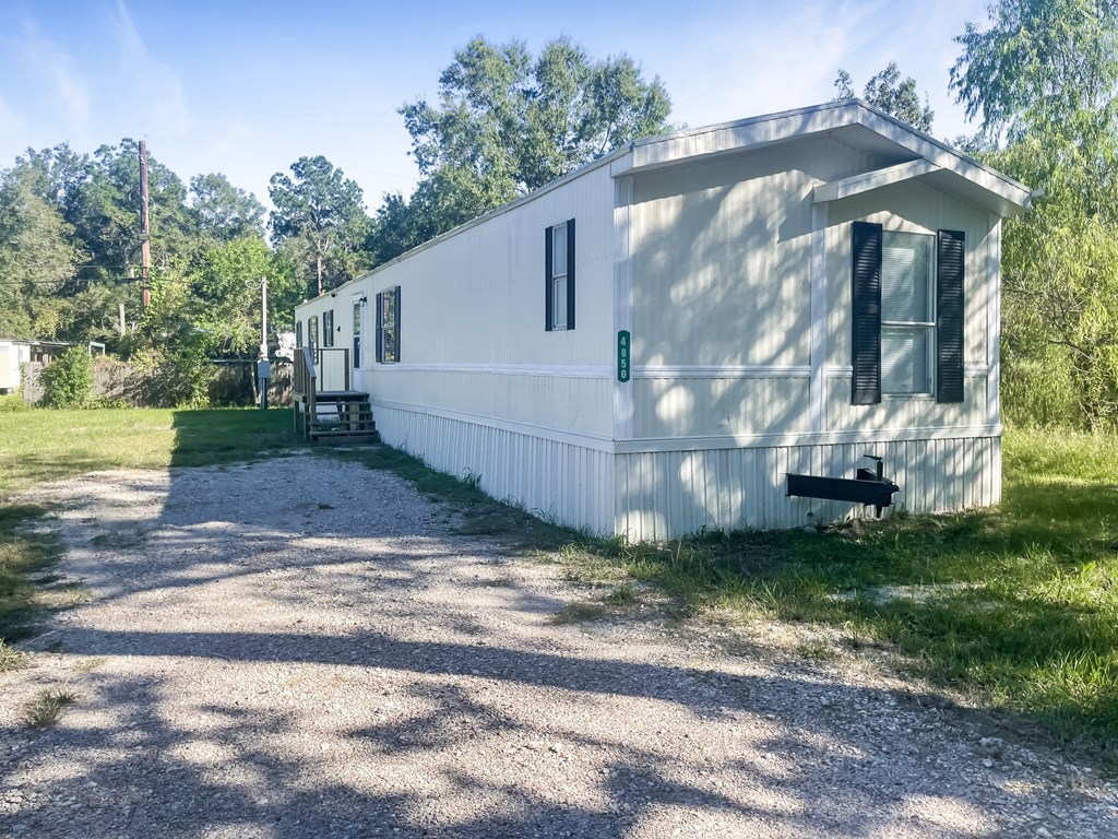 a white trailer is parked next to a dirt road