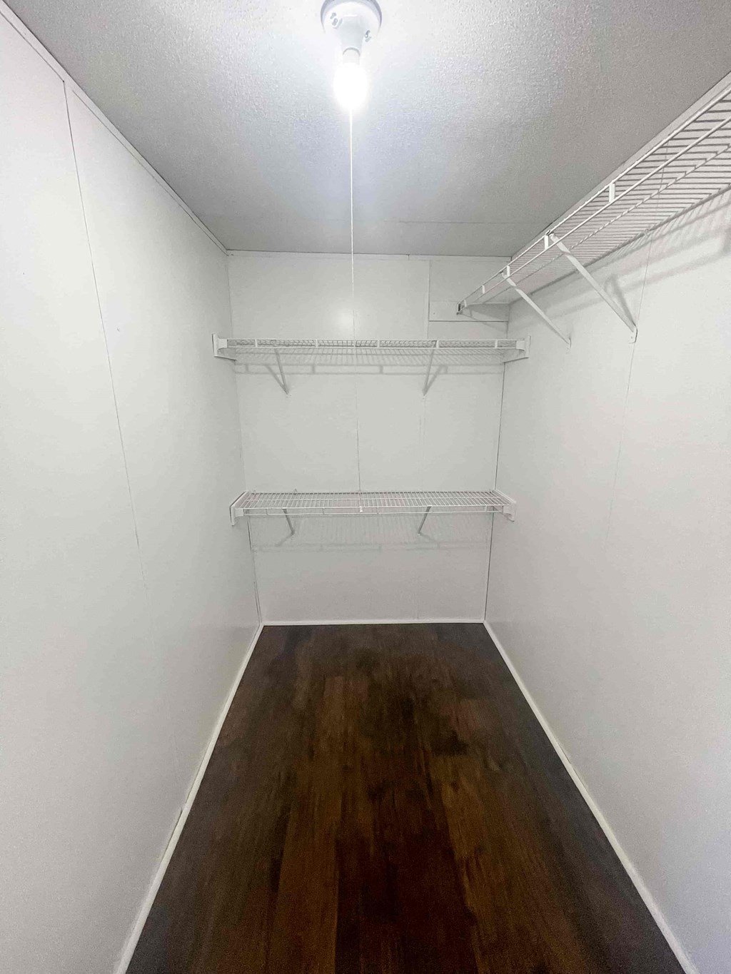 a empty room with white walls and a wood floor