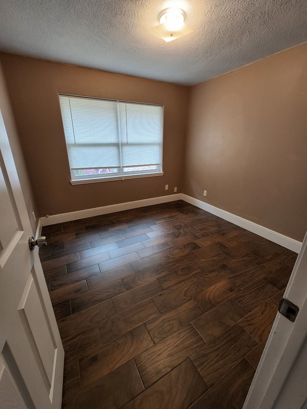a living room with wood floors and a window