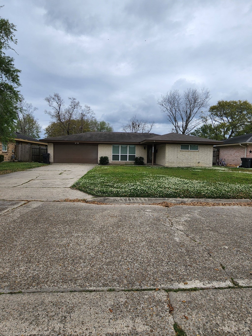the front of a house with a driveway and lawn