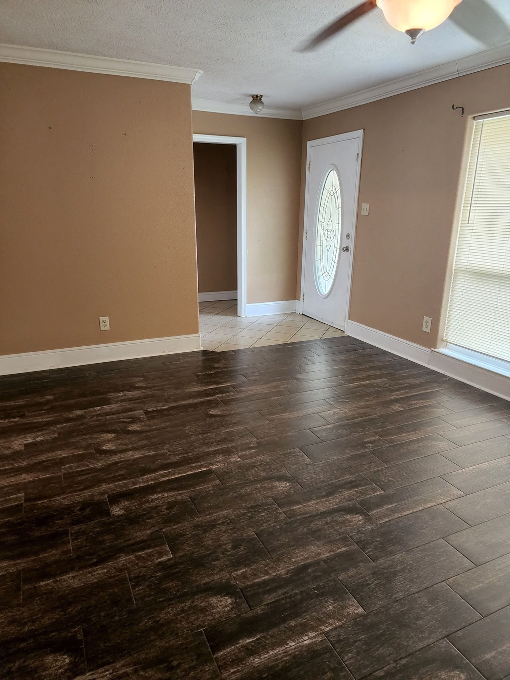 an empty living room with wood flooring and a door with a window