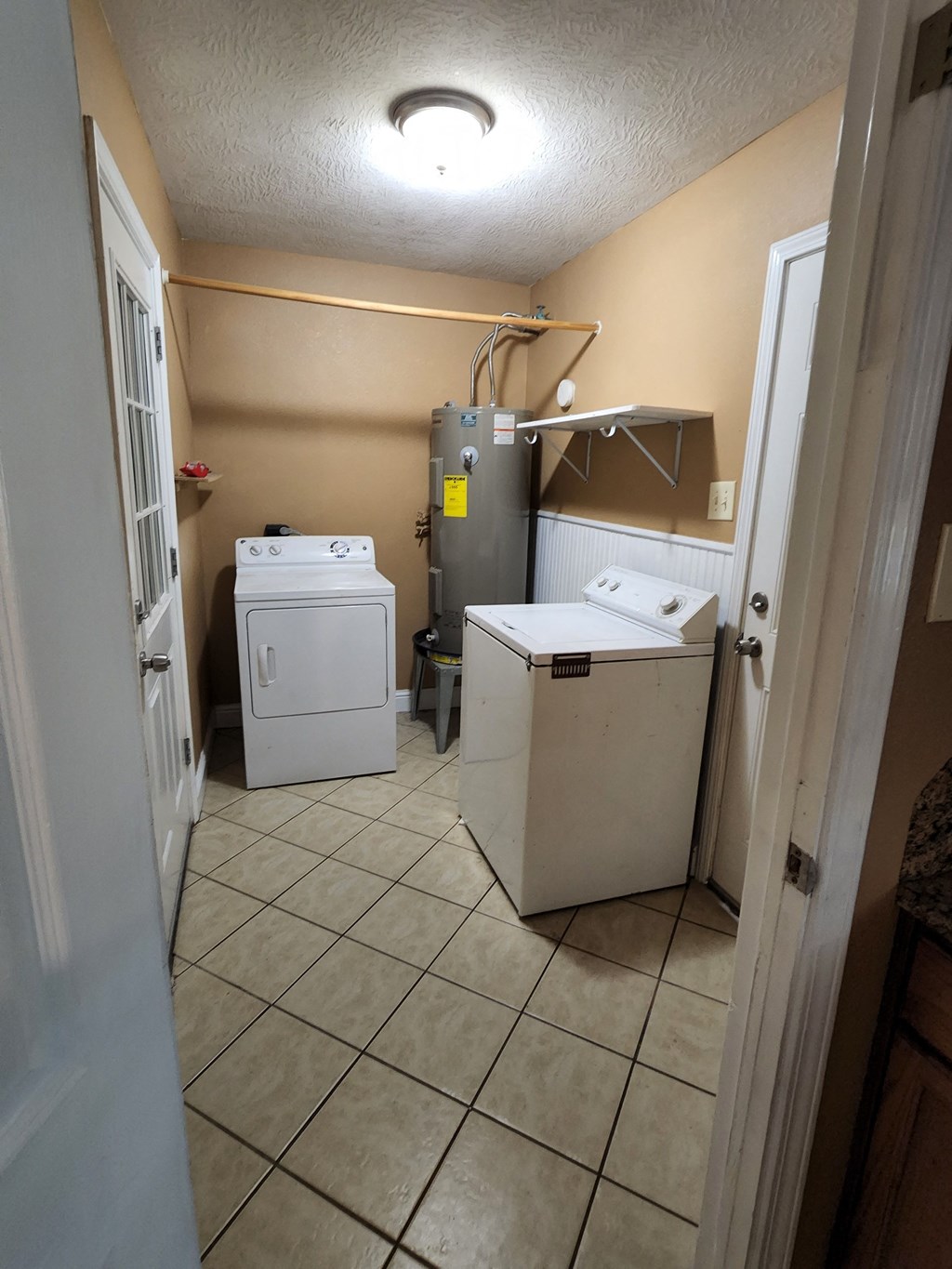a laundry room with two washers and a dryer in it