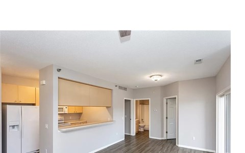A kitchen with white cabinets and a refrigerator is shown.