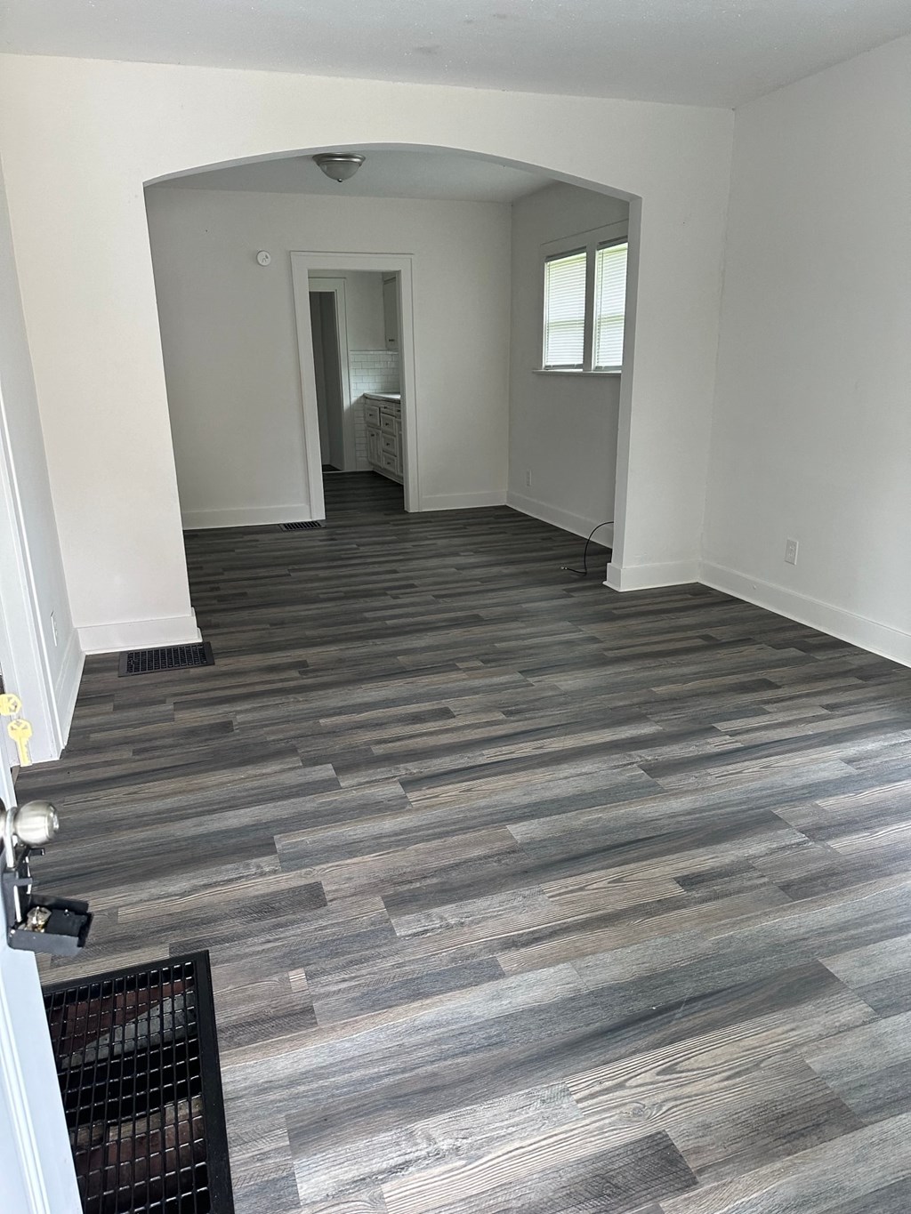 a living room with wood flooring and white walls